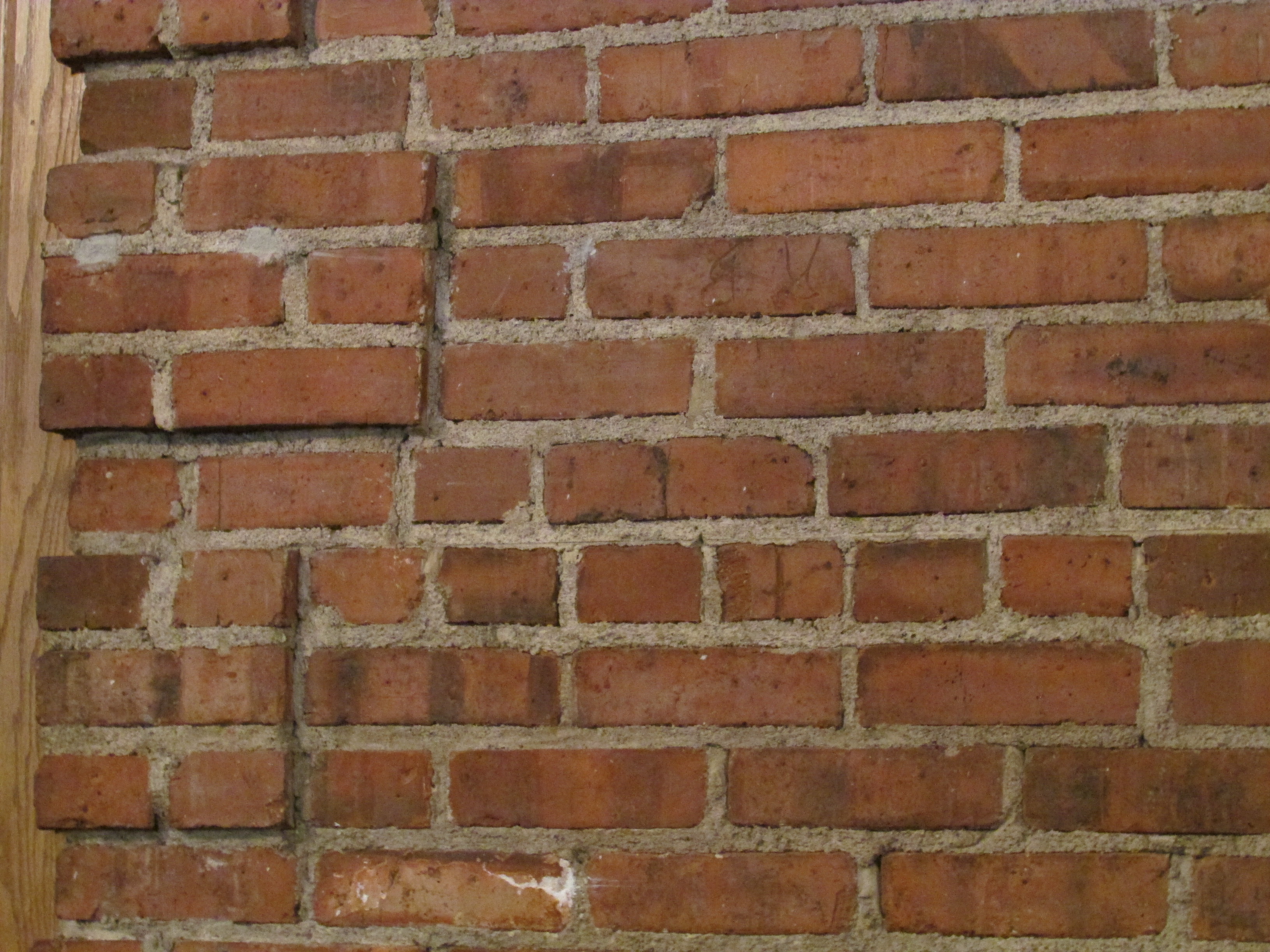 Brick coursing in alternating bond — block structure, each course load-bearing on what's underneath.